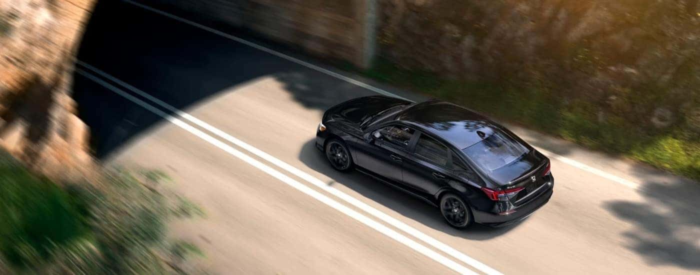Black 2025 Honda Civic Sport driving on a highway