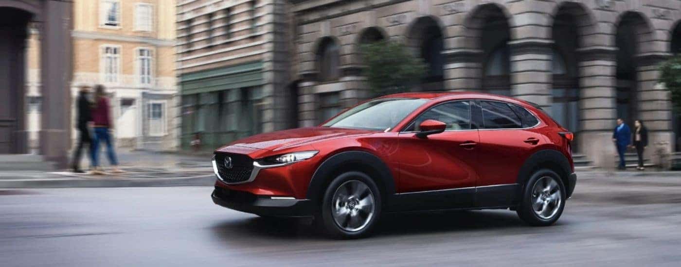 A red 2024 Mazda CX-30 shown from the side driving.