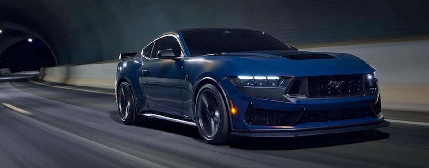 A blue 2024 Mustang Dark Horse Premium driving in a tunnel.