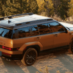 A brown 2025 Hyundai Santa Fe parked on a dirt road surrounded by trees.