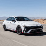 White 2025 Hyundai Elantra N turning on a racetrack with red accents and black wheels