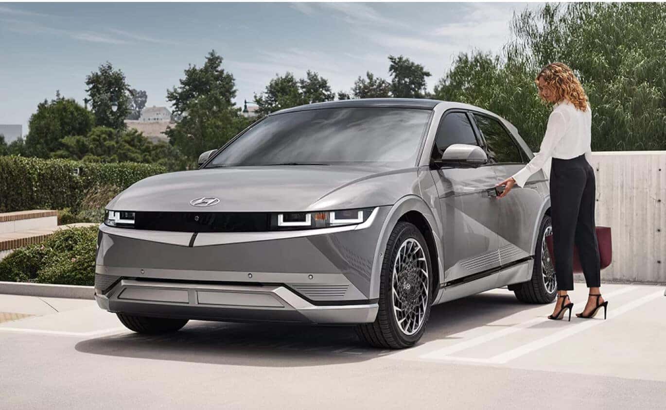 Front three-quarter view of a Hyundai IONIQ 5 Limited in Cyber Gray Metallic parked in a concrete lot.
