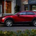 A red 2020 Mazda CX-30 is parked on a city street after leaving a Mazda dealer.