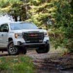 A white 2021 GMC Canyon is on a trail in the woods near Indiana, PA.