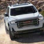A white 2020 GMC Acadia AT4 is off-roading on a dirt tail near Indiana, PA.