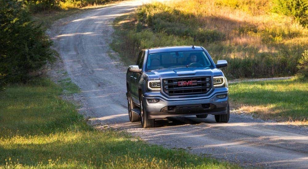 A gray 2017 GMC Sierra 1500 is driving on a dirt road near Indiana, PA.