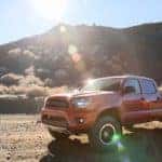 A red 2014 used Toyota Tacoma TRD is parked in the desert.