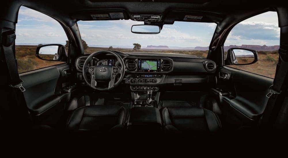 The black dashboard and interior of a 2019 Toyota Tacoma is shown.