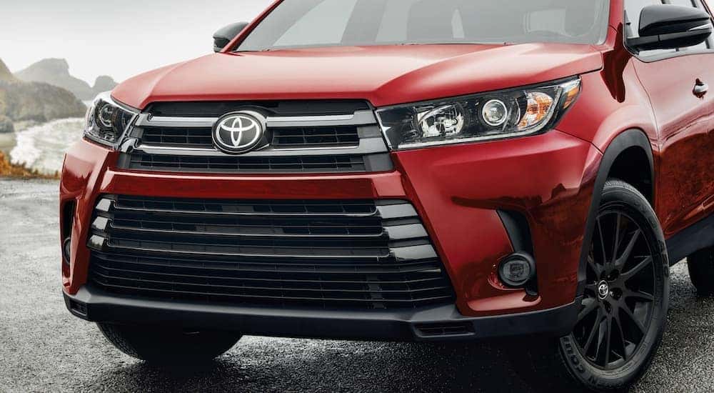 A close up shows the grille and bowtie of a red 2019 Toyota Highlander.