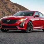 A red 2020 Cadillac CT5-V is parked on a road in the desert.