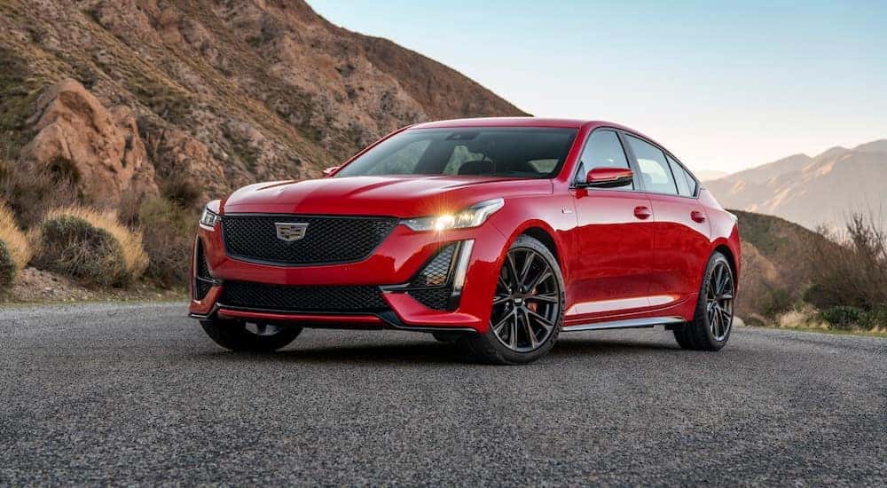 A red 2020 Cadillac CT5-V is parked on a road in the desert.