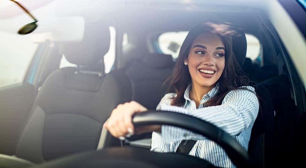 A woman is shown driving a car.