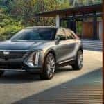 A silver 2023 Cadillac Lyriq is shown parked in front of a modern home.
