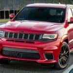 A red 2017 used Jeep Grand Cherokee Trackhawk is driving around the racetrack.