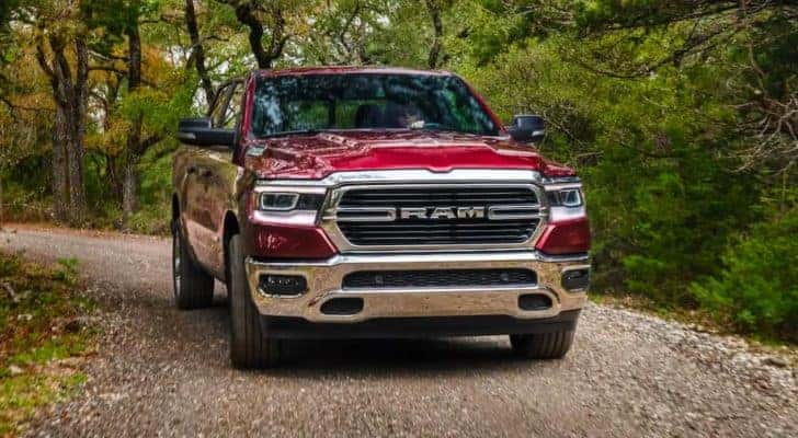 A red 2020 Ram 1500 is shown from the front on a dirt path after leaving a used Ram dealer in KY.