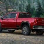 A red 2020 GMC Sierra 2500 is shown from the rear parked in the forest.