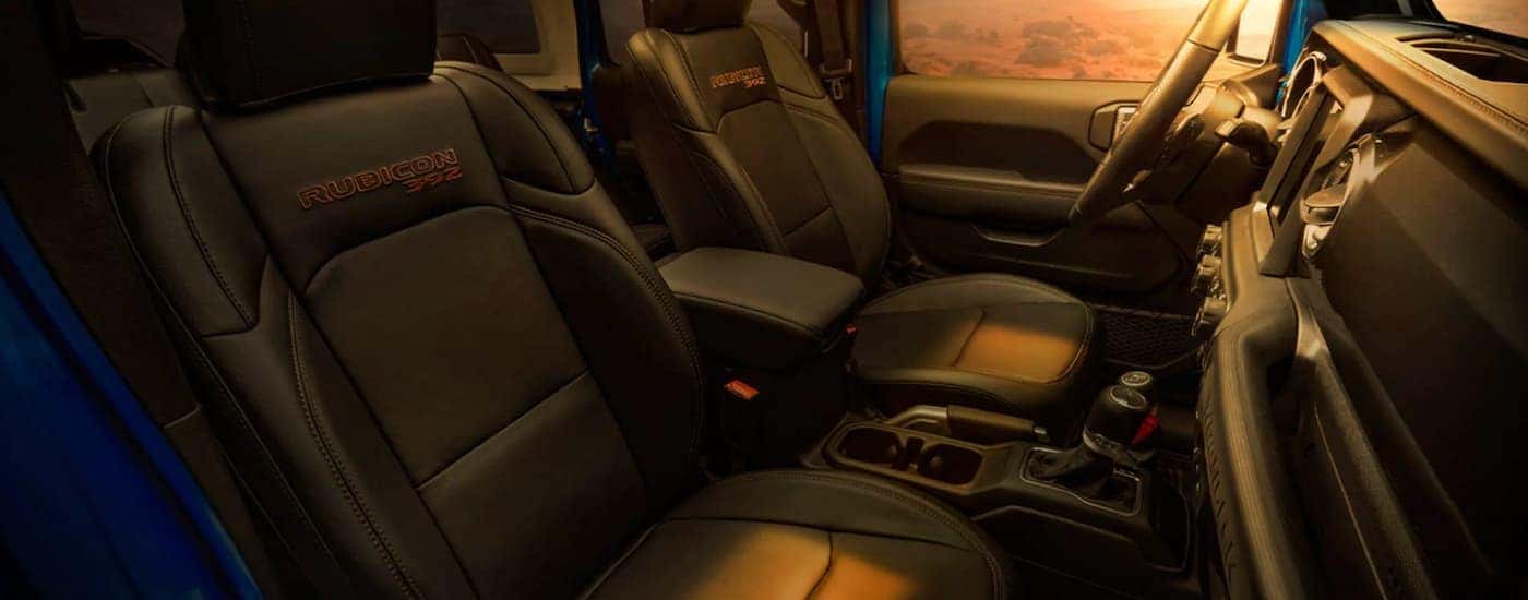 The black interior of a 2021 Jeep Wrangler Rubicon 392 shows two front seats.