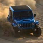 A blue 2022 Jeep Wrangler Rubicon Xtreme Recon is shown off-roading in the desert.