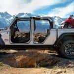 A silver 2020 used Jeep Gladiator Rubicon is shown from the side with no doors in the mountains.