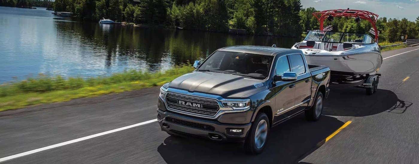 A black 2024 Ram 1500 is shown towing a boat.