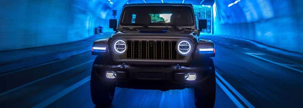 2025 Jeep Wrangler vs. 2025 Ford Bronco | Delaney CDJR of DuBois | Front profile of a 2025 Jeep Wrangler driving through a tunnel