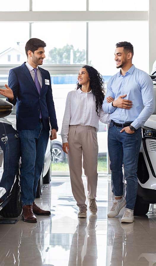 Leasing versus Buying a Chrysler Dodge Jeep RAM at Delaney CDJR of DuBois in DuBois, PA | Salesman showing a couple the vehicles available in the dealership