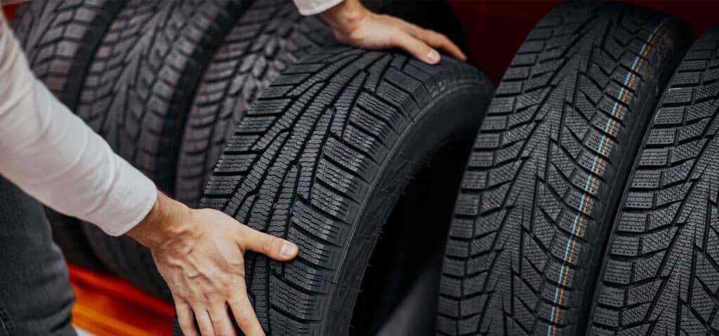 How to check your tires' health at Delaney Hyundai of Dubois | Person grabbing a brand new tire off the tire rack