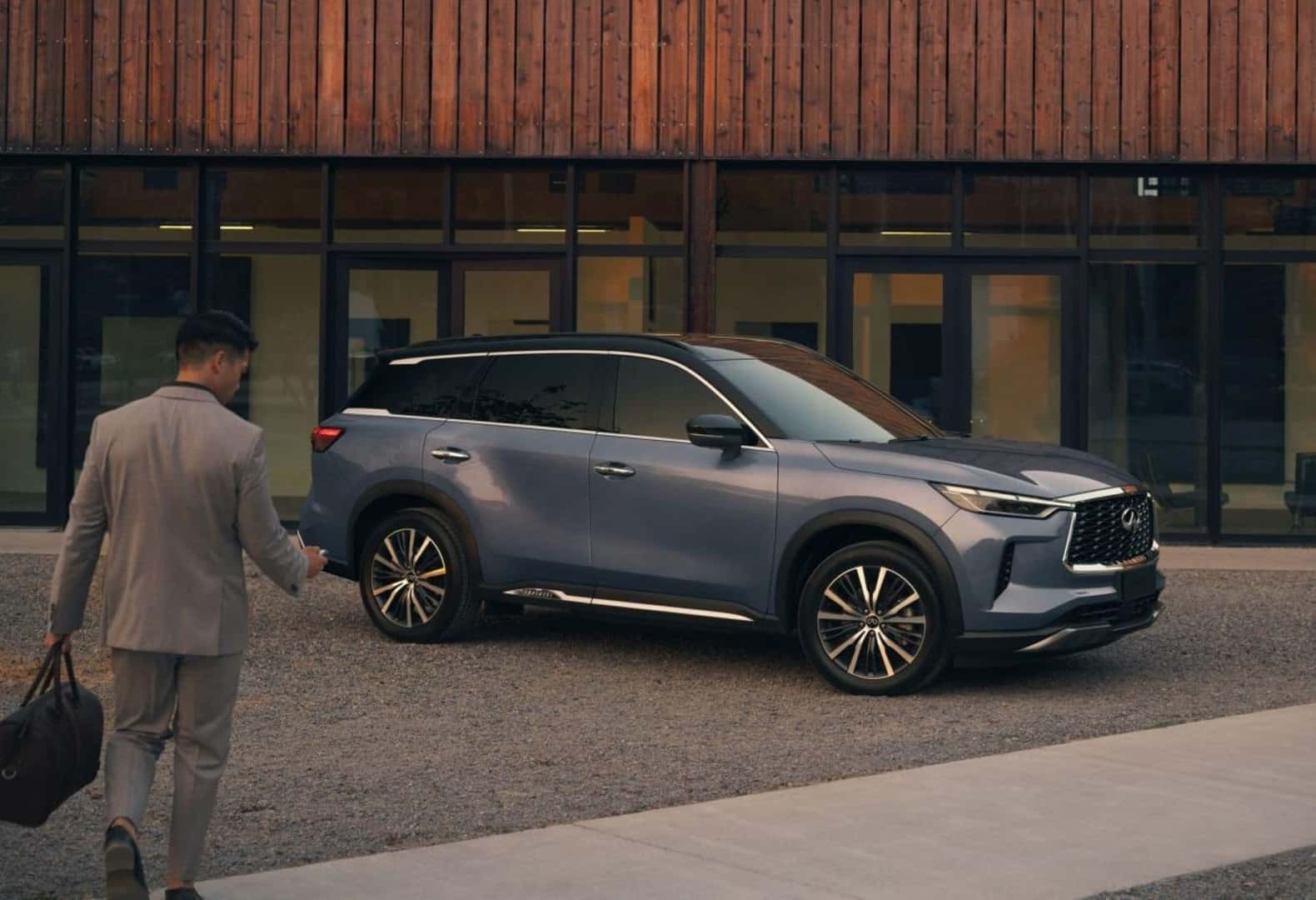 A INFINITI Driver Wirelessly Unlocking Their 2025 INFINITI QX60, Parked Glamorously