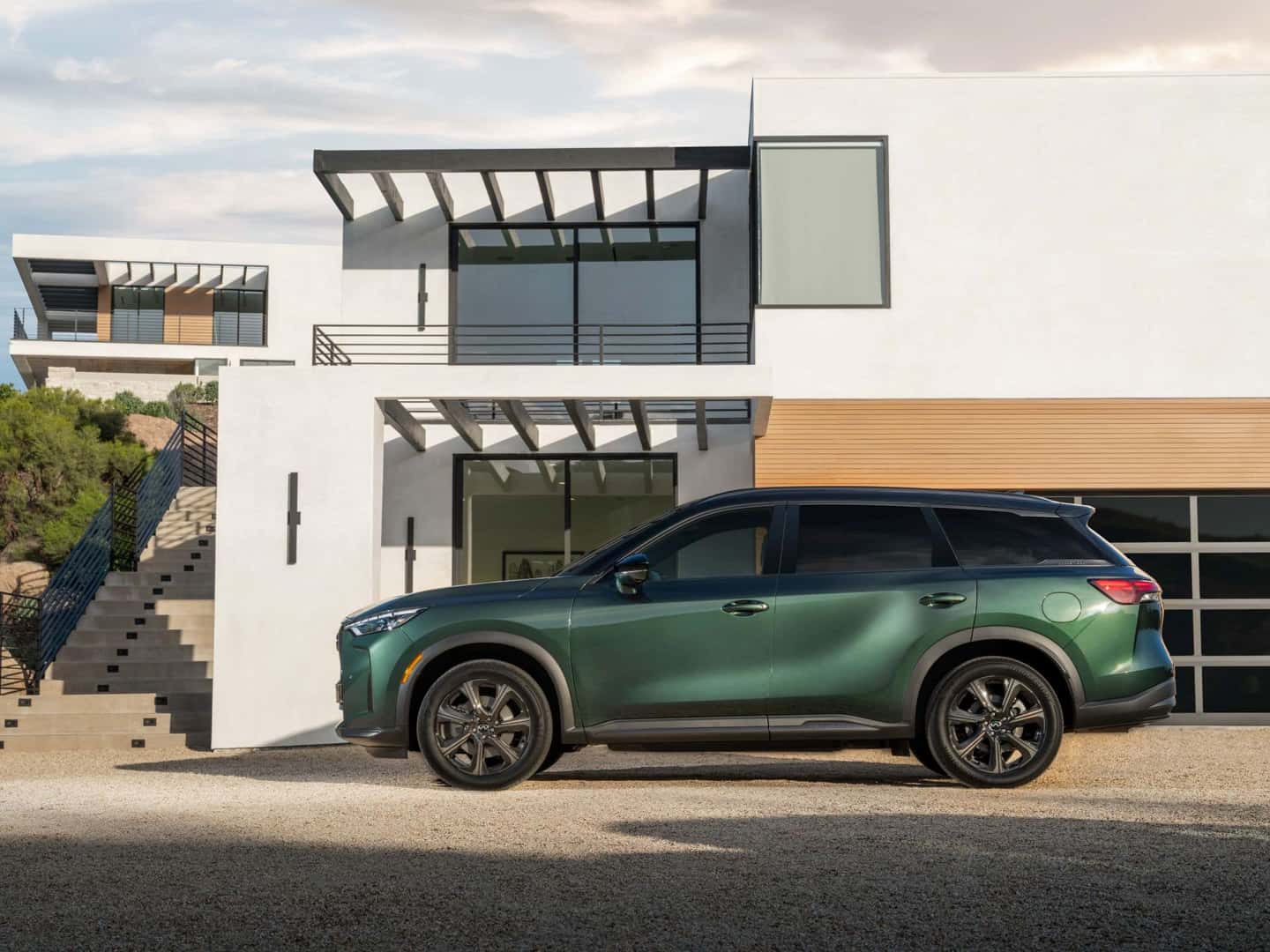 The Sexy Side Profile Of The Spectacular SUV: The 2026 INFINITI QX60. It's Parked Outside A Modern Home