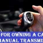 A hand holding a gearstick in a manual transmission car