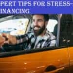 A man on the wheel smiling after buying a car