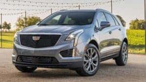 A silver 2020 Cadillac XT5 under string lights facing left