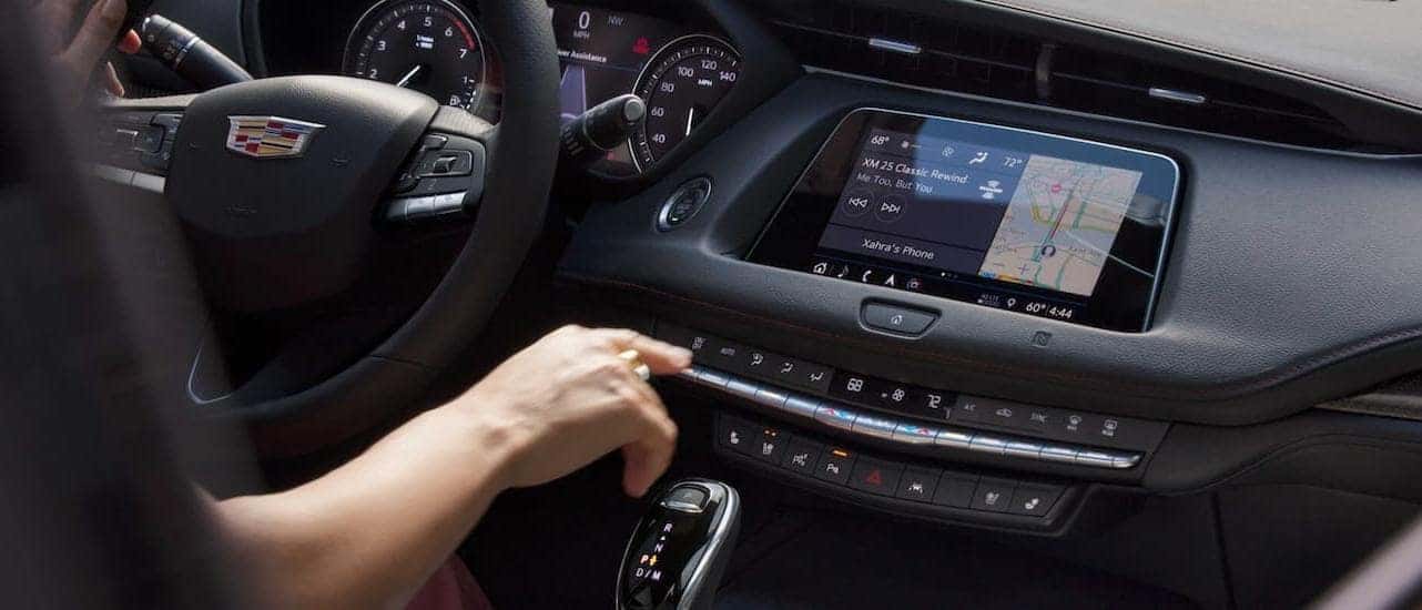 A driver is using the touchscreen inside the 2020 Cadillac XT4.