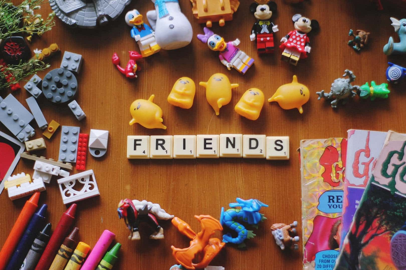 A Collection of Children's Toys and the Word 'Friends' Spelled Out with Scrabble Pieces