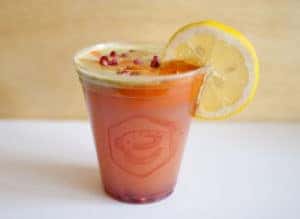 cold pressed juice drink with lemon garnish
