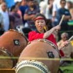 Japanese Festival woman drumming in the park for a crowd of people