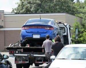 Towing a blue car in a tow truck in Fort Worth, TX