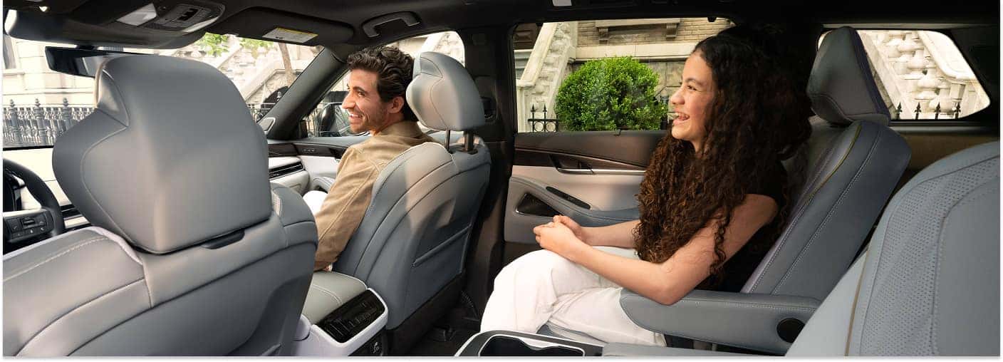 Interior seating of a 2026 INFINITI QX60 showing light gray leather seats and passengers inside the cabin.