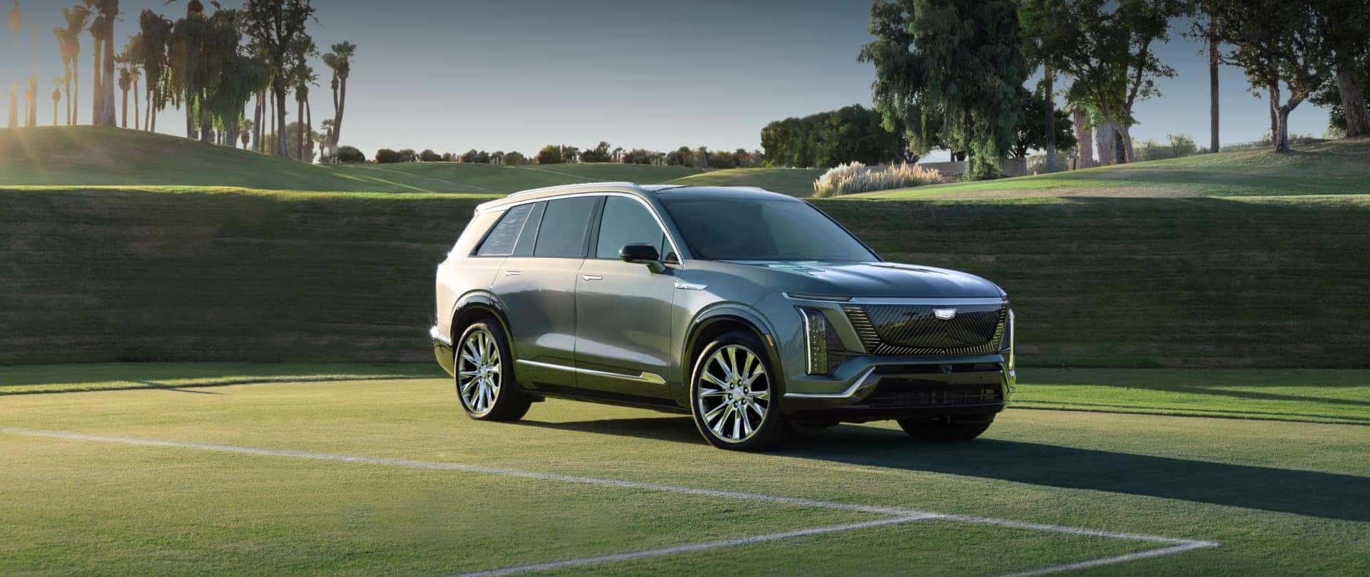 Three-quarters View of a 2026 Cadillac VISTIQ Parked on a Grassy Tennis Court