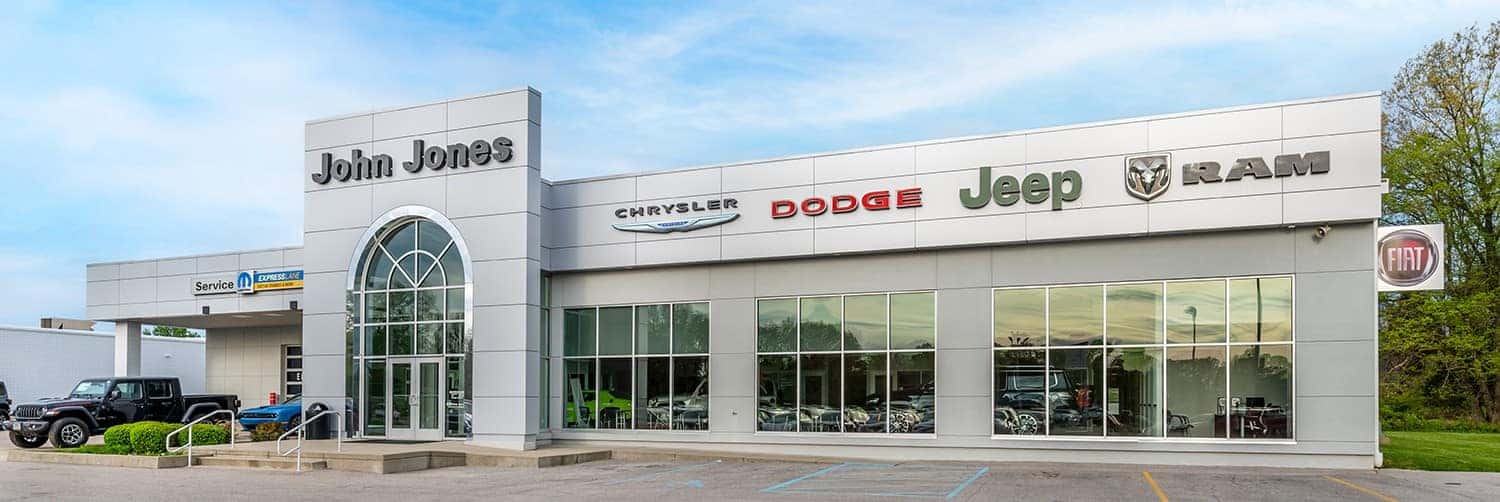 American flag flying over vehicle lineup at John Jones Chrysler Dodge Jeep Ram