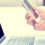 person using a cell phone and lap top