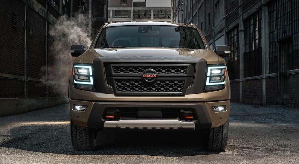 A brown 2021 Nissan Titan Pro4x is shown from the front while parked in an alley.