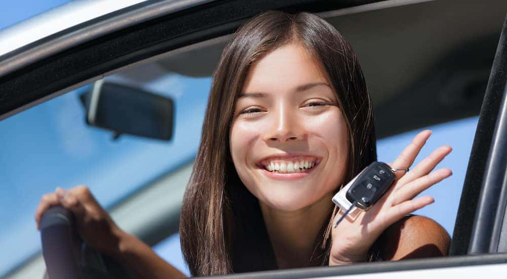 A teen driver is holding a set of keys.