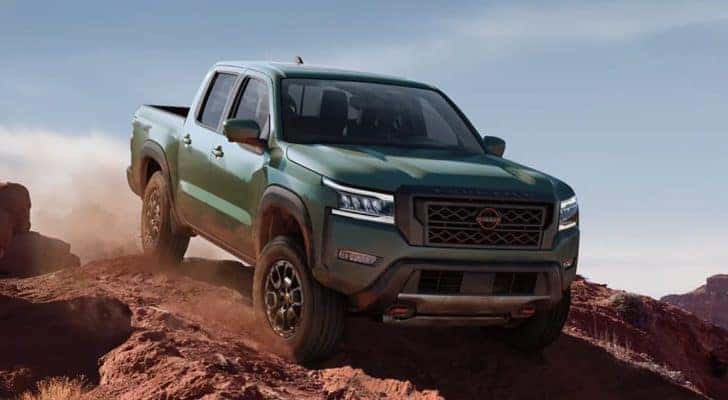 A green 2022 Nissan frontier is shown from the front off-roading in the desert after leaving a Nashville Nissan Frontier dealer.