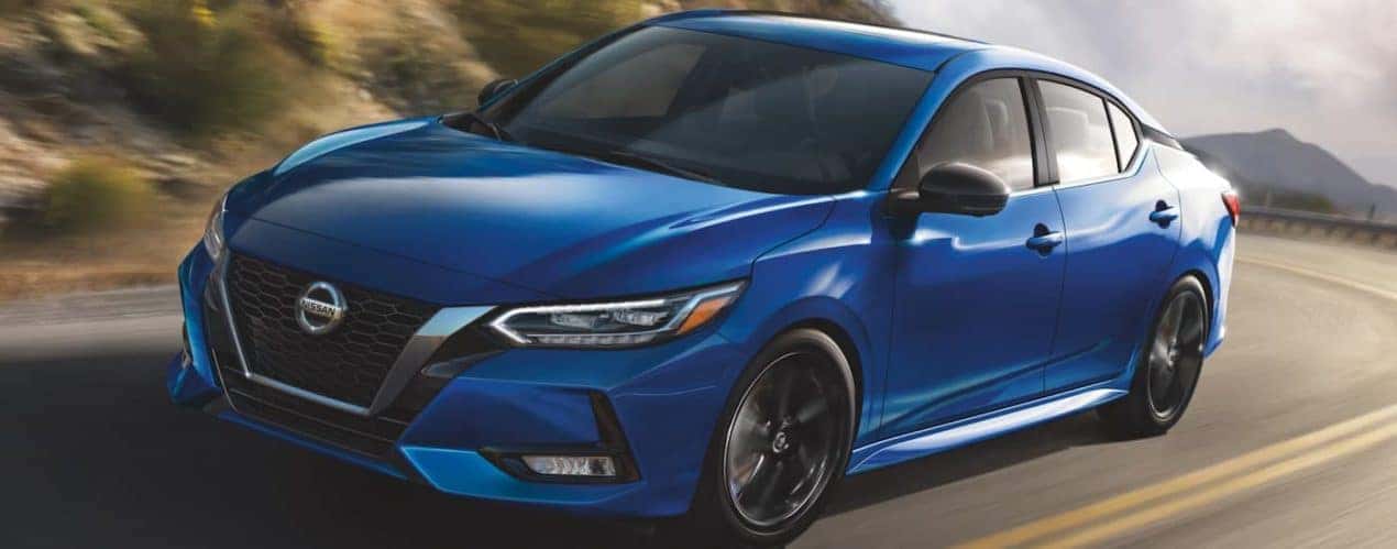A blue 2022 Nissan Sentra is shown from the side driving on an open road.