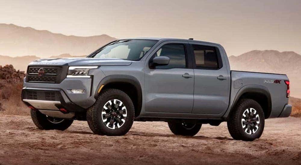 A grey 2022 Nissan Frontier Pro-4x is shown from the side while parked off-road.