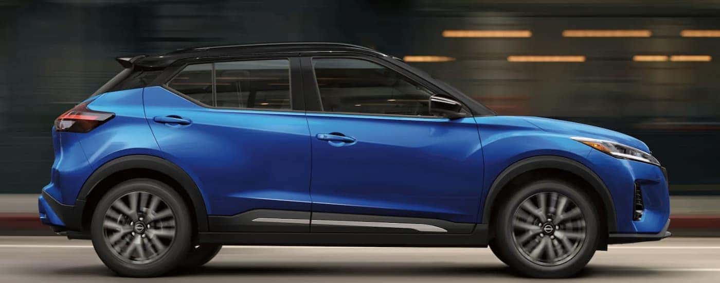 A blue 2022 Nissan Kicks is shown from the side driving after leaving a Nissan SUV dealer.