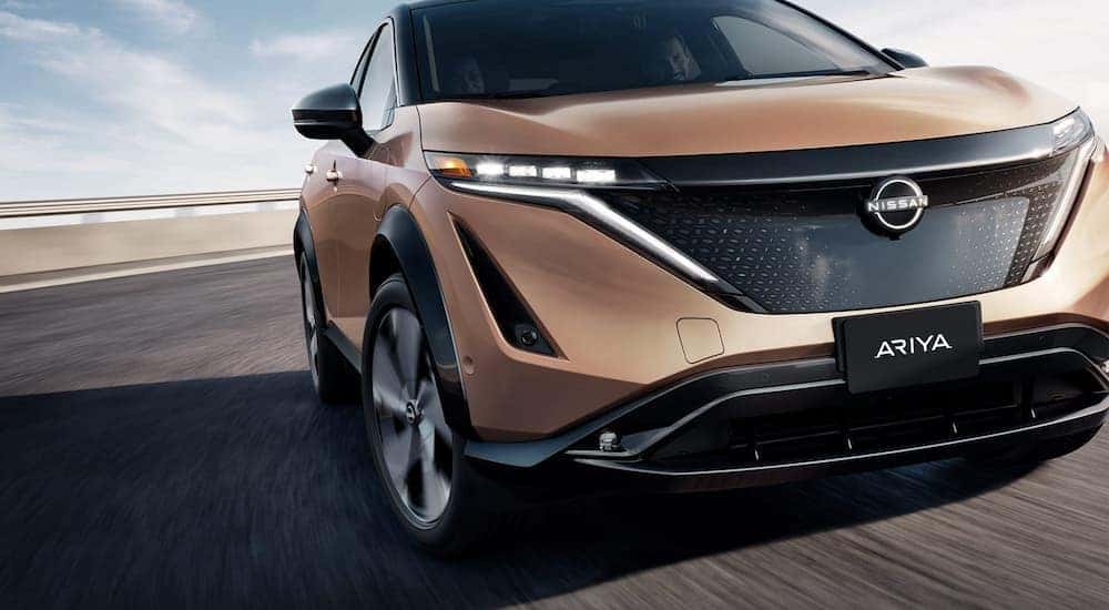 A gold 2023 Nissan ARIYA is shown after leaving a Nissan SUV dealer.
