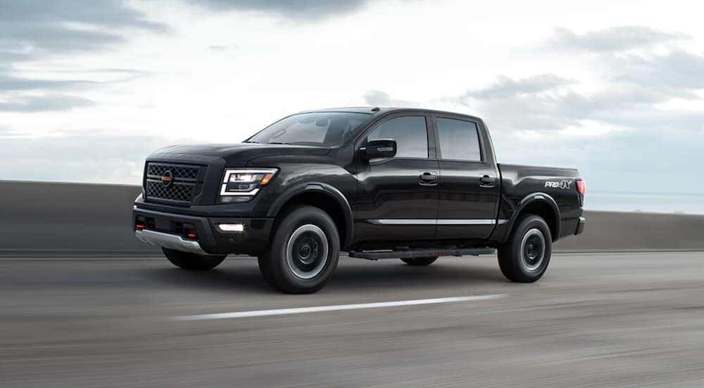 A black 2022 Nissan Titan Pro-4x is shown from the side on the highway.