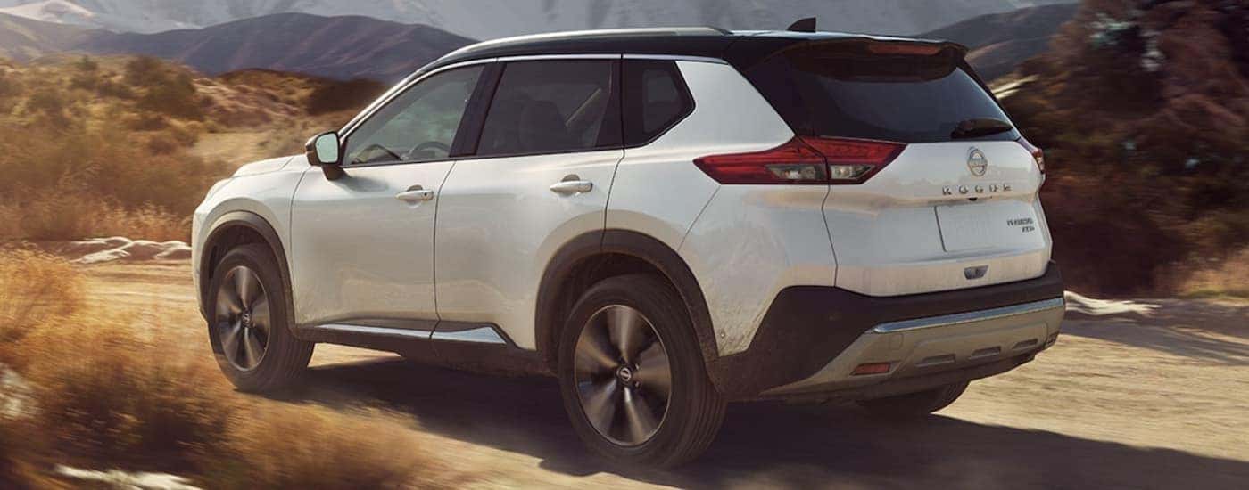 A popular Nissan Rogue in Columbia, a white 2023 Nissan Rogue, is shown driving on a dirt road.